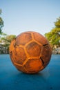 Old yellow soccer ball on the blue football field Royalty Free Stock Photo