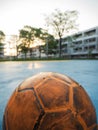 Old yellow soccer ball on the blue football field Royalty Free Stock Photo