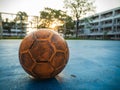 Old yellow soccer ball on the blue football field Royalty Free Stock Photo