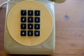 Old yellow telephone with black key pad Royalty Free Stock Photo