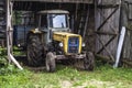 Old yellow tractor inside garage Royalty Free Stock Photo