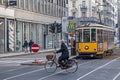 Old yellow tram and senior man bicyclist. Street in Milan,Italy