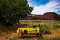 Old yellow wagon in prairie overlooking valley and distance mountains