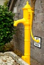 Old yellow water pump in Macroom square Ireland