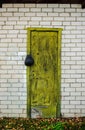 Old yellow wooden door with a lock in white brick wall Royalty Free Stock Photo