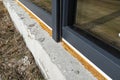 Old yellowed mounting foam under a large terrace window, visible styrofoam insulating the foundations of the house. Royalty Free Stock Photo