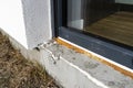 Old yellowed mounting foam under a large terrace window, visible styrofoam insulating the foundations of the house. Royalty Free Stock Photo