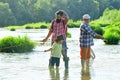 Old and young. Father, son and grandfather relaxing together. Fishing in river. Young - adult concept. Happy fisherman Royalty Free Stock Photo