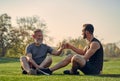 The old and young sportsmen greeting on the grass. Royalty Free Stock Photo