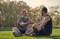 The old and young sportsmen handshaking on the grass. Royalty Free Stock Photo