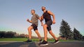 The old and young sportsmen running on the alley.