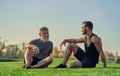 The old and young sportsmen sitting on the grass. Royalty Free Stock Photo