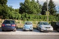 Old Zastava 750, blue color, in poor condition, parked on a parking next to more modern cars.