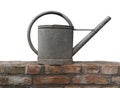 Old zinc watering can on a brick wall isolated