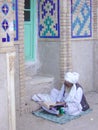 Old Muslim in turban reads at Afghan shrine