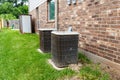 Two older HVAC air conditioner systems next to brick home with copy space Royalty Free Stock Photo