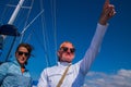 Older baby boomer caucasian couple with man pointing into the distance. Deep blue sky with sailboat rigging in background