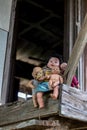 Group of baby dolls sitting on old wooden stairs