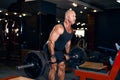 Older bald sportsman lifting weights working out in gym doing exercise for back muscles with barbell