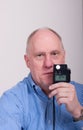 Older Balding Man in Blue Shrt Light Meter Reading