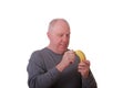 Older Balding Man in Grey Shirt Peeling a Banana