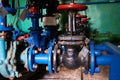 Old black valve with red handles on the blue-painted cold water pipeline. Royalty Free Stock Photo