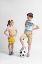 The older boy with the soccer ball looks at the younger girl appraisingly Royalty Free Stock Photo