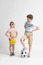 The older boy with the soccer ball looks at the younger girl appraisingly Royalty Free Stock Photo