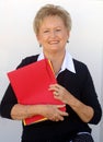 Older business woman with file folders