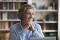 Older businesswoman sit at desk, distracted from work looks aside Royalty Free Stock Photo