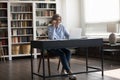 Older businesswoman sit at desk talks on smartphone to client