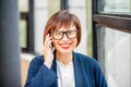 Older businesswoman talking phone indoors Royalty Free Stock Photo