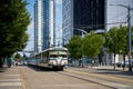 An older car of the lrt station streetcar train rides through the modern city of Calgary