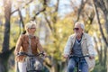 Older Caucasian couple riding bicycles through public park together Royalty Free Stock Photo