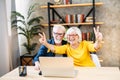 Older couple looks on laptop with a winery smiles Royalty Free Stock Photo