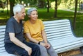 Older couple resting in park seated on bench enjoy talk Royalty Free Stock Photo