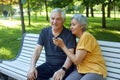 Older couple resting in park seated on bench enjoy talk Royalty Free Stock Photo