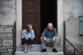 Bale / Croatia - 7/18/2019: Older man and woman sitting on the steps in front of their doorstep