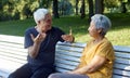 Older couple talking seated on bench in summer park Royalty Free Stock Photo