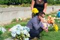 Older Couple wearing protective mask against COVID-19 SARS-CoV-2 coronavirus mourns their relatives at the cemetery Royalty Free Stock Photo