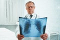 Older doctor examines x-ray image Royalty Free Stock Photo