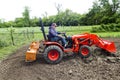 Older Gentleman Tilling His Garden With A Compact 4x4 Tractor Royalty Free Stock Photo