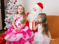 The older girl is sitting on lap of Santa Claus and tells poem Royalty Free Stock Photo