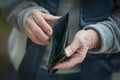 Older hands holding textured empty wallet, highlighting wrinkles and aged veins Royalty Free Stock Photo