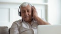 Older happy man wearing wireless headphones, enjoying favorite music. Royalty Free Stock Photo