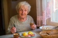 Older happy woman eating at home at the table. Royalty Free Stock Photo