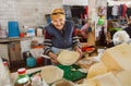 Older happy woman sells organic homemade cheese on Georgian village farmer`s market