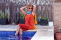 Older Hispanic woman in a sundress smiling and posing while in the pool - concept of vacation Royalty Free Stock Photo