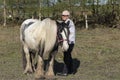 Older lady with a black and white irish cob horse