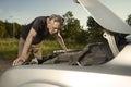 Older man alone on route checking unfunctional engine in late summer light Royalty Free Stock Photo